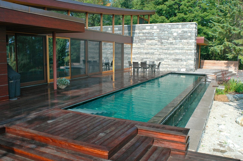 Mid-sized contemporary backyard rectangular lap pool in Toronto with decking.