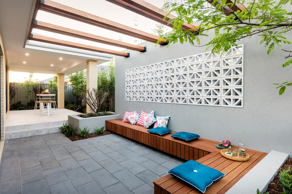 Large contemporary backyard patio in Perth with a container garden, a roof extension and concrete pavers.