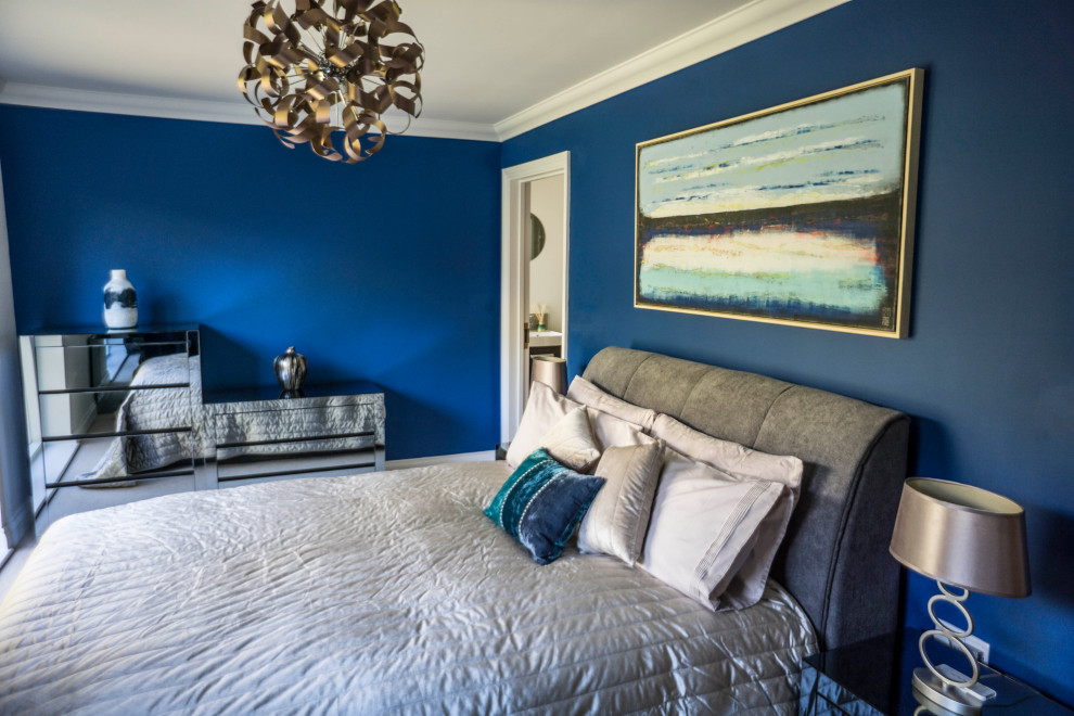 Inspiration for a mid-sized contemporary master bedroom in Kent with blue walls, carpet and beige floor.