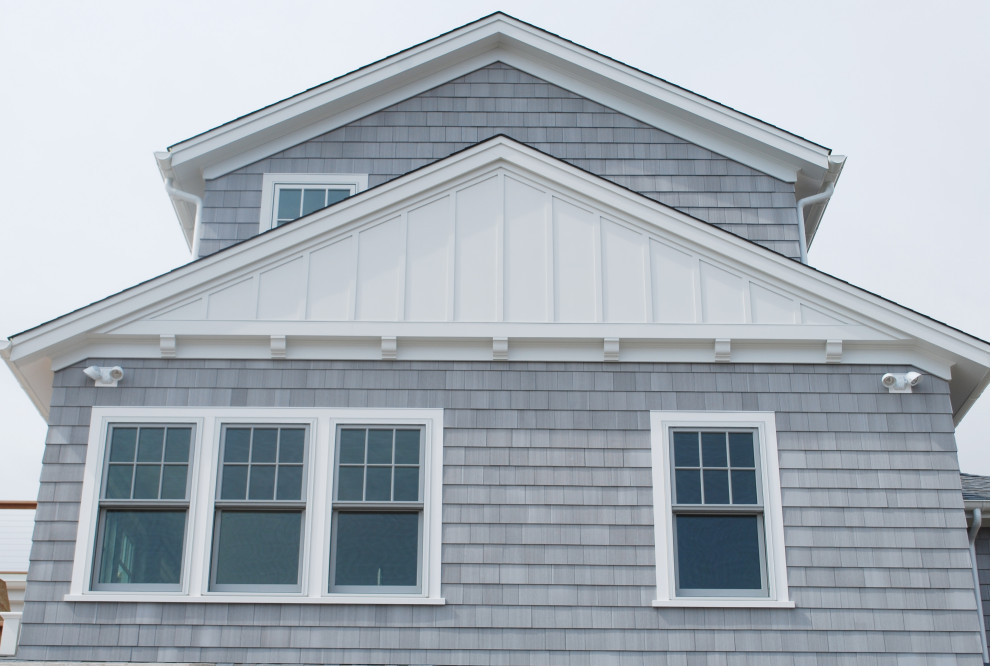 Foto de fachada de casa gris y gris marinera grande de dos plantas con revestimiento de madera, tejado a dos aguas y teja