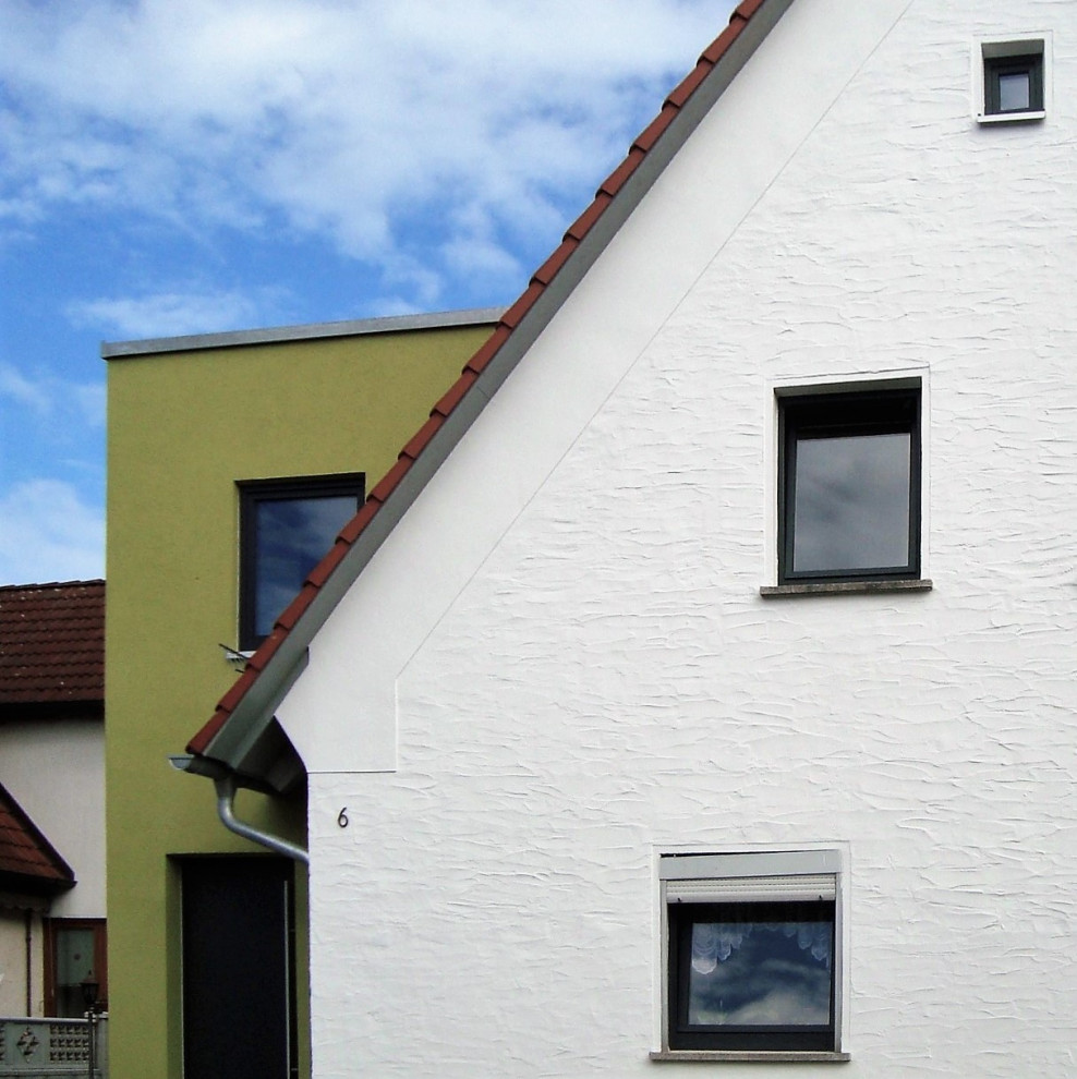 Cette photo montre une façade de maison blanche chic en briques peintes de taille moyenne et à un étage avec un toit à deux pans, un toit en tuile et un toit rouge.