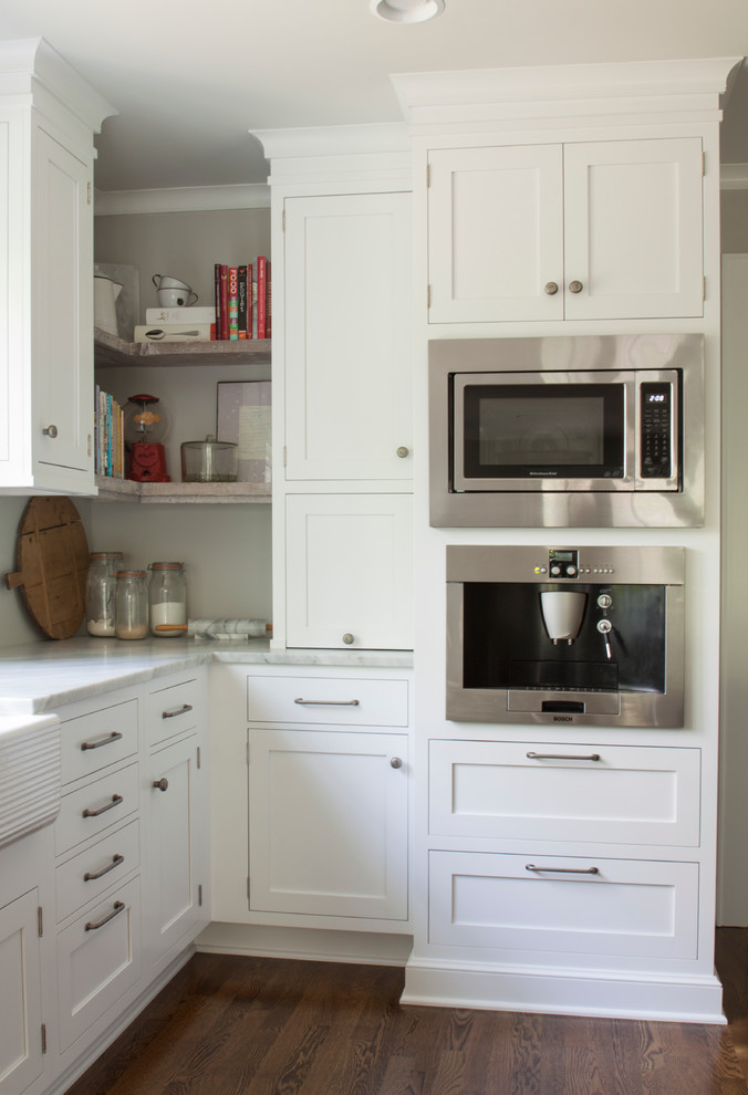 Enclosed kitchen - large transitional l-shaped dark wood floor enclosed kitchen idea in Newark with a farmhouse sink, shaker cabinets, white cabinets, marble countertops, white backsplash, stainless steel appliances and an island