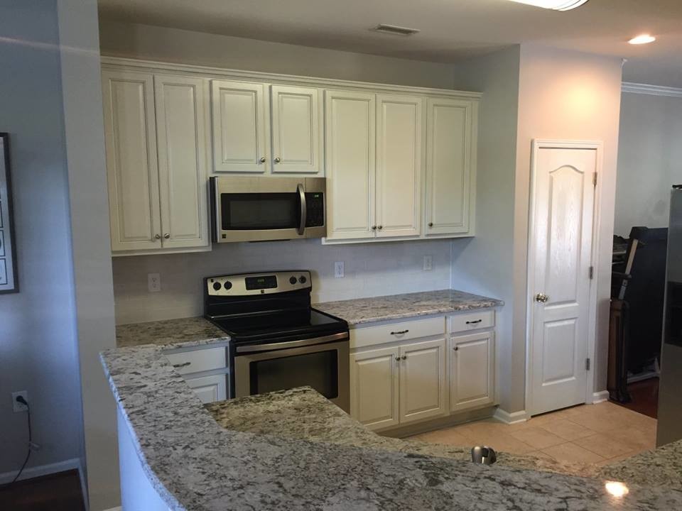 Example of a mid-sized transitional u-shaped ceramic tile home design design in Charlotte with an undermount sink, raised-panel cabinets, white cabinets, granite countertops, white backsplash, subway tile backsplash, stainless steel appliances and no island