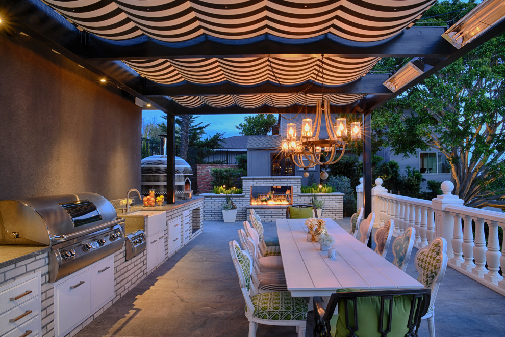 Inspiration for a modern backyard patio in San Diego with an outdoor kitchen, natural stone pavers and a pergola.