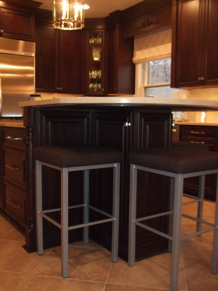 Kitchen - large transitional kitchen idea with a single-bowl sink, raised-panel cabinets, dark wood cabinets, marble countertops, stainless steel appliances and an island