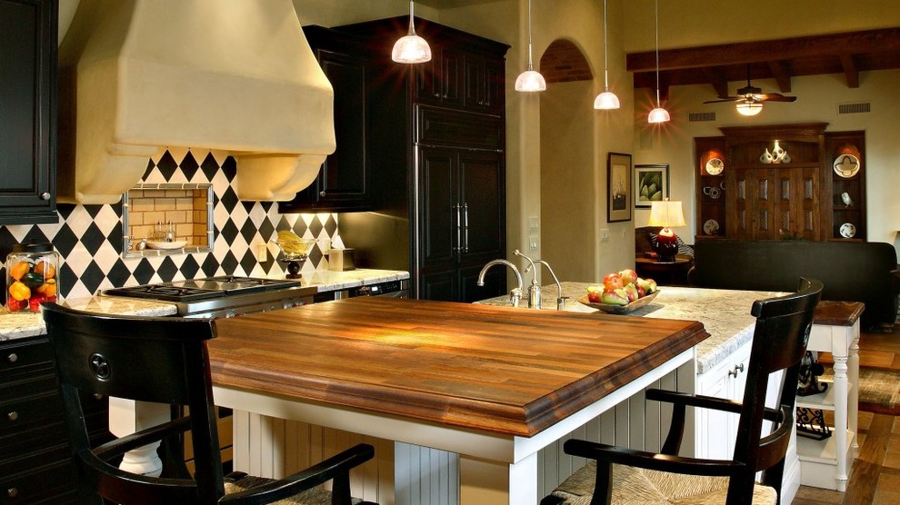 Inspiration for a mediterranean u-shaped ceramic tile open concept kitchen remodel in Phoenix with an undermount sink, beaded inset cabinets, black cabinets, marble countertops, multicolored backsplash, ceramic backsplash, stainless steel appliances and an island