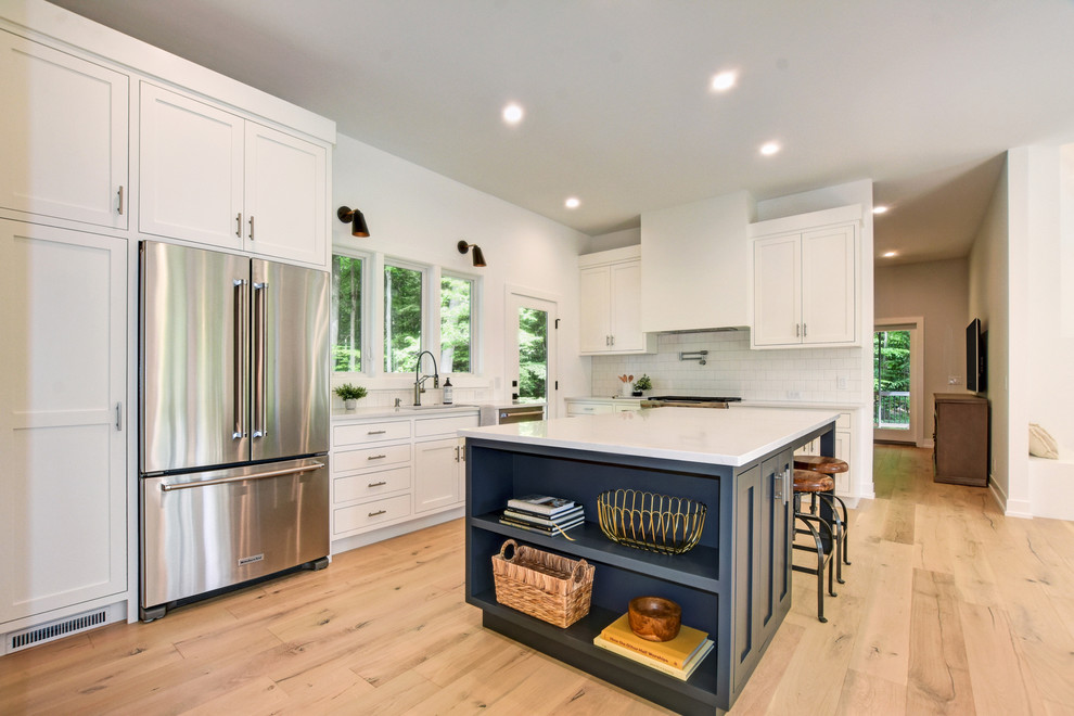 Inspiration for a transitional kitchen in Grand Rapids with quartz benchtops, stainless steel appliances, light hardwood floors, with island and white benchtop.