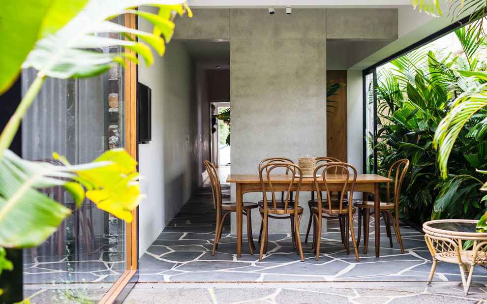 Photo of a tropical side yard patio in Sydney with a roof extension.