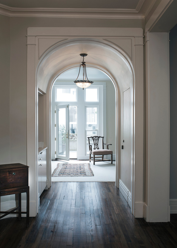 Inspiration for a mid-sized traditional hallway in DC Metro with beige walls, dark hardwood floors and black floor.