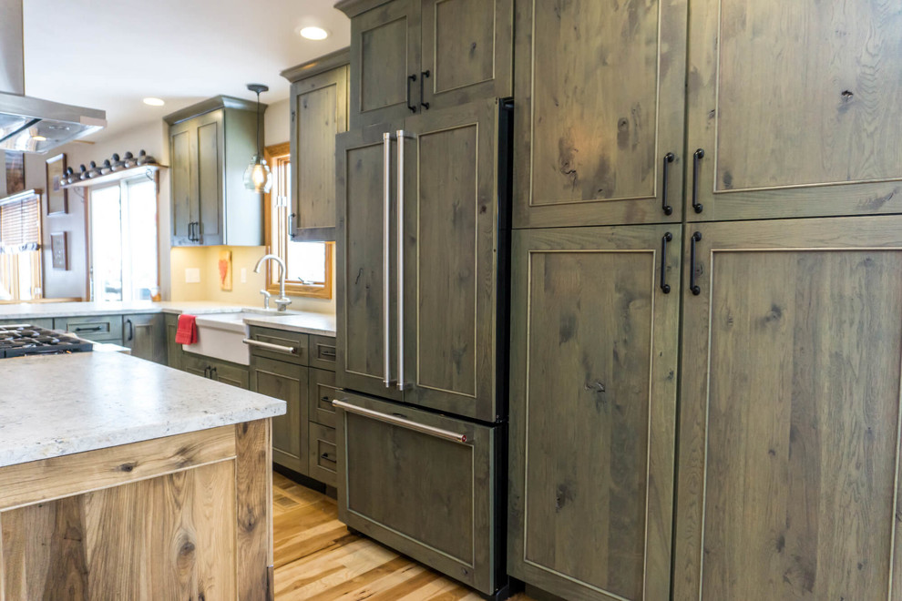 Open concept kitchen - large rustic light wood floor and brown floor open concept kitchen idea with beaded inset cabinets, distressed cabinets, granite countertops, an island and white countertops