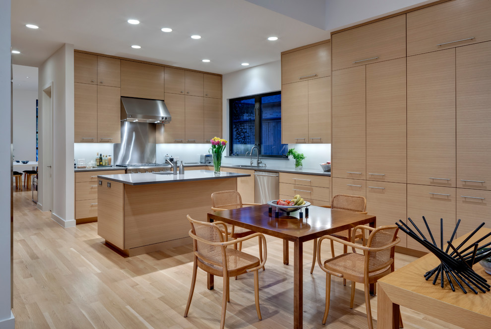 Inspiration for a contemporary l-shaped eat-in kitchen in Dallas with an integrated sink, flat-panel cabinets, light wood cabinets, quartzite benchtops, white splashback, stainless steel appliances, glass sheet splashback, light hardwood floors and with island.