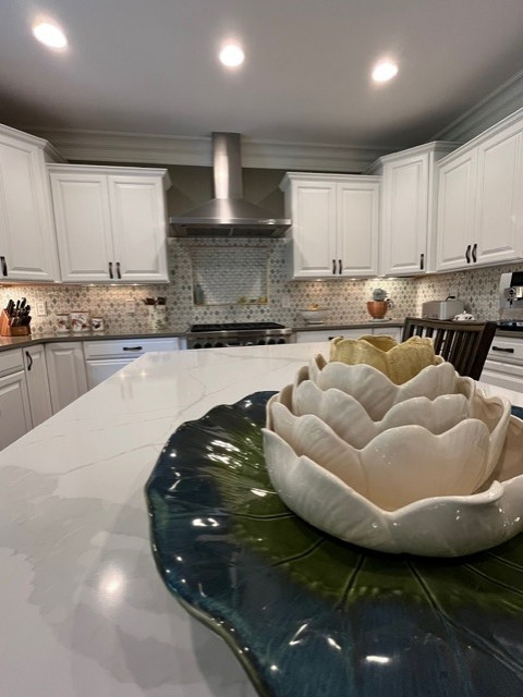 Large transitional u-shaped eat-in kitchen photo with raised-panel cabinets, white cabinets, quartz countertops, green backsplash, mosaic tile backsplash, stainless steel appliances, an island and green countertops