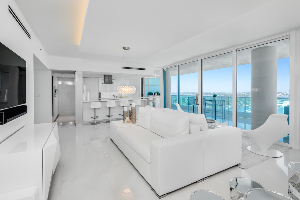 Design ideas for a contemporary living room in Miami with white walls, a wall-mounted tv and white floor.