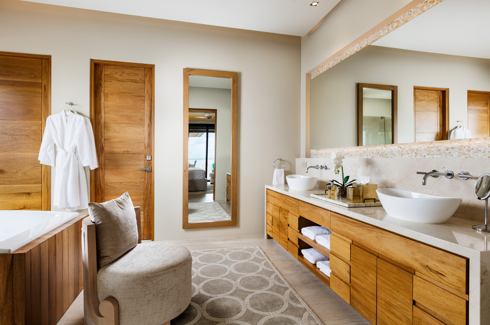 This is an example of a master bathroom in Salt Lake City with flat-panel cabinets, medium wood cabinets, beige walls and a vessel sink.