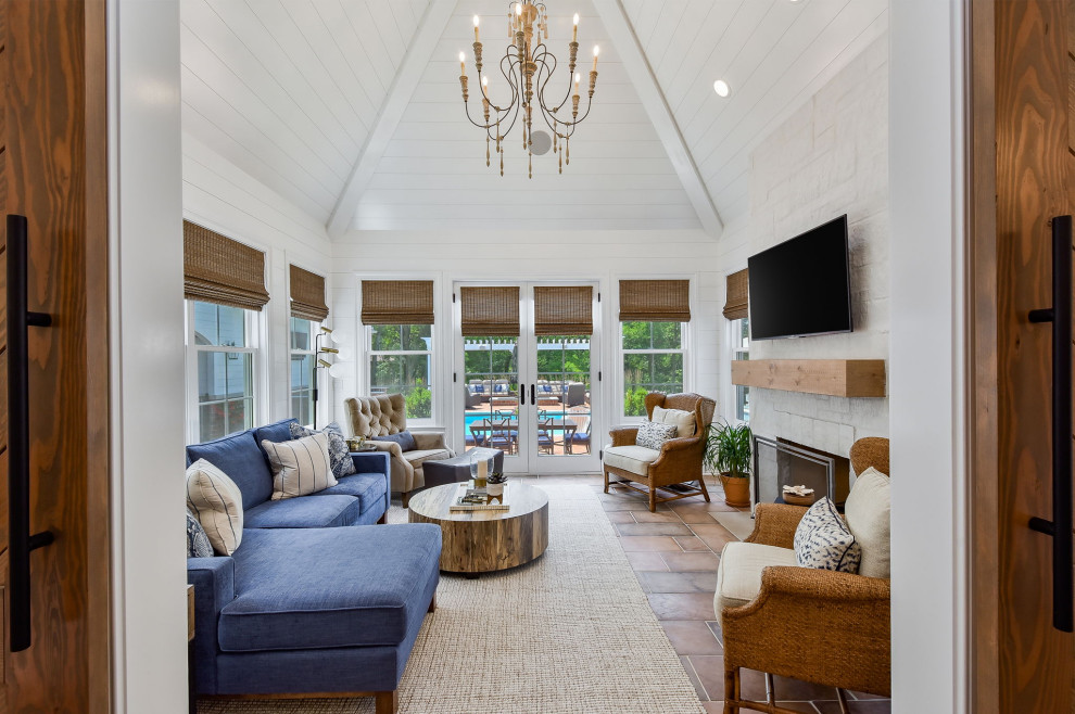Photo of a mid-sized transitional sunroom in Chicago with terra-cotta floors, a standard fireplace, a stone fireplace surround, a standard ceiling and orange floor.