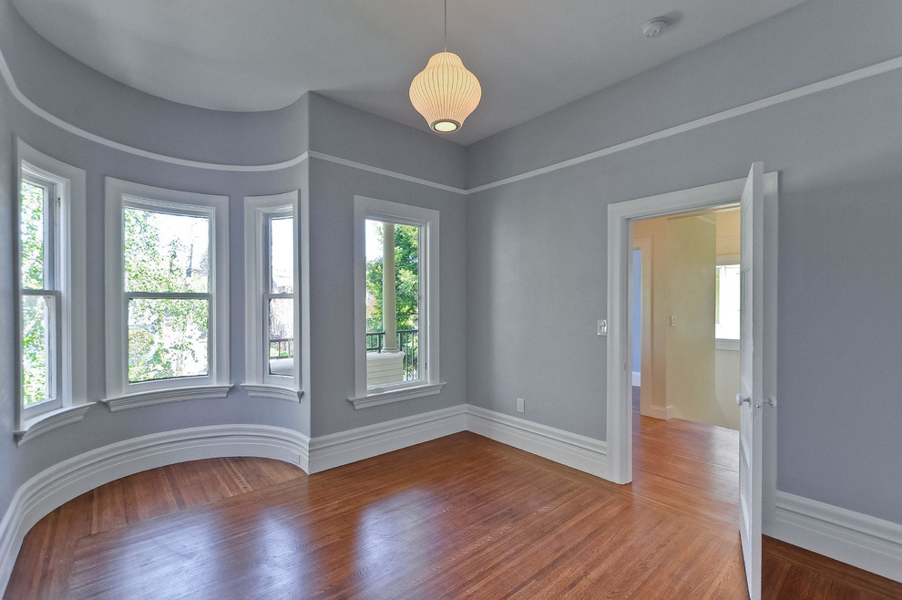 This is an example of a mid-sized traditional master bedroom in San Francisco with grey walls, medium hardwood floors and no fireplace.