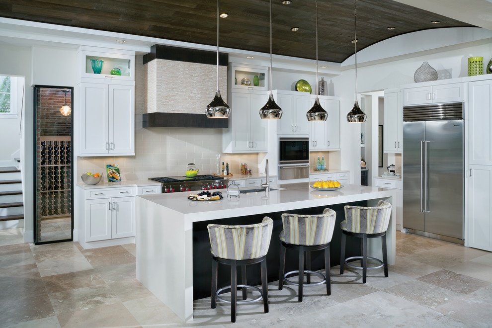 This is an example of an expansive transitional l-shaped eat-in kitchen in Tampa with an undermount sink, recessed-panel cabinets, white cabinets, quartzite benchtops, beige splashback, ceramic splashback, stainless steel appliances, ceramic floors and with island.