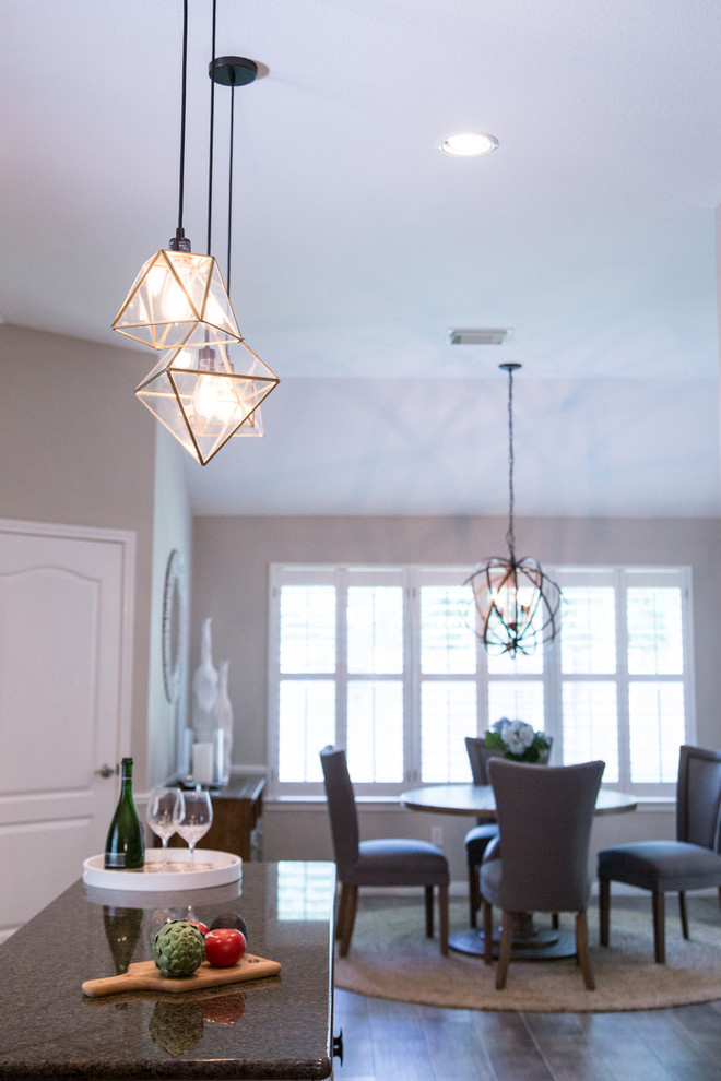 Inspiration for a transitional u-shaped porcelain tile and brown floor kitchen remodel in Austin with beige cabinets, granite countertops, white backsplash, subway tile backsplash, stainless steel appliances and an island