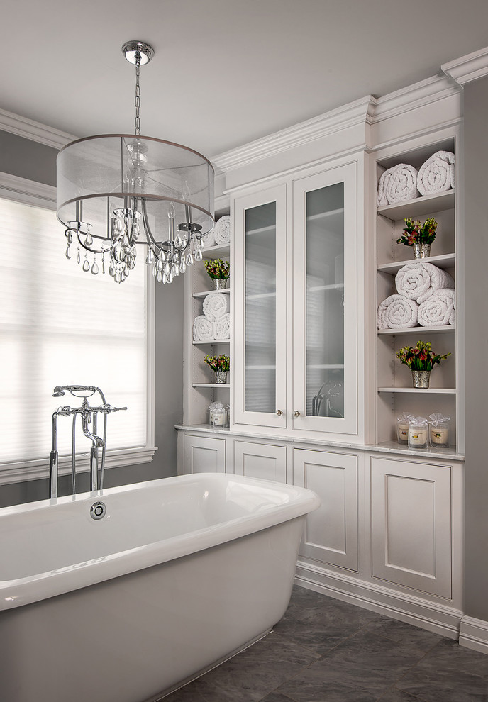 Mid-sized transitional master white tile and subway tile gray floor and ceramic tile freestanding bathtub photo in Detroit with furniture-like cabinets, white cabinets, a two-piece toilet, gray walls, an undermount sink, marble countertops, a hinged shower door and white countertops