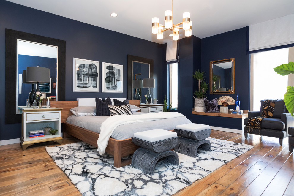Large modern master bedroom in Philadelphia with blue walls, medium hardwood floors and brown floor.