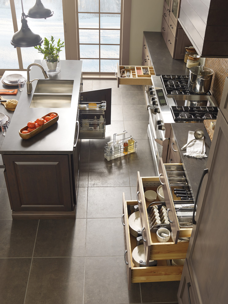 Example of a large transitional single-wall porcelain tile open concept kitchen design in Toronto with a double-bowl sink, flat-panel cabinets, dark wood cabinets, soapstone countertops, brown backsplash, ceramic backsplash, stainless steel appliances and an island