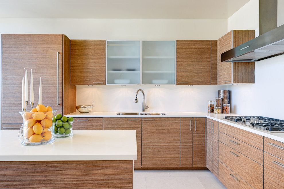 Mid-sized contemporary l-shaped kitchen in Los Angeles with an undermount sink, flat-panel cabinets, medium wood cabinets, white splashback and with island.