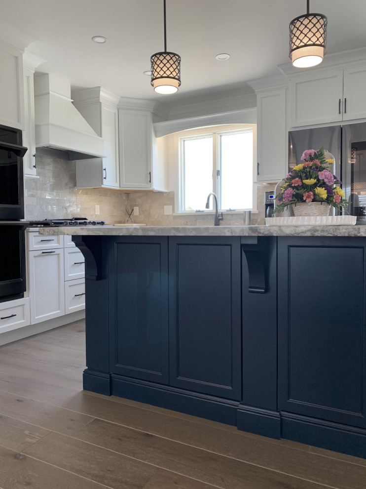 Eat-in kitchen - large transitional l-shaped vinyl floor and gray floor eat-in kitchen idea with an undermount sink, recessed-panel cabinets, white cabinets, quartz countertops, gray backsplash, ceramic backsplash, stainless steel appliances, an island and white countertops