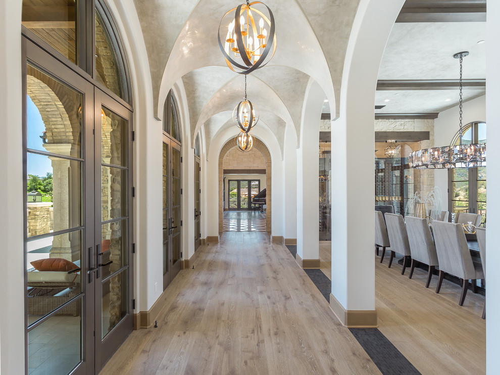 Design ideas for a mediterranean hallway in San Francisco with white walls, medium hardwood floors and brown floor.