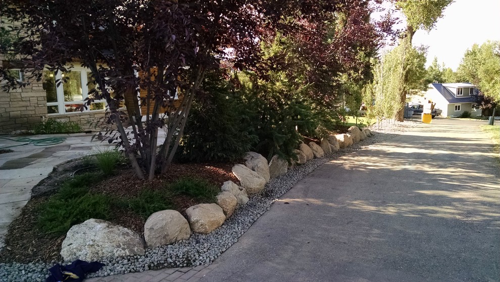 This is an example of a mid-sized traditional backyard driveway in Denver with a garden path and natural stone pavers.