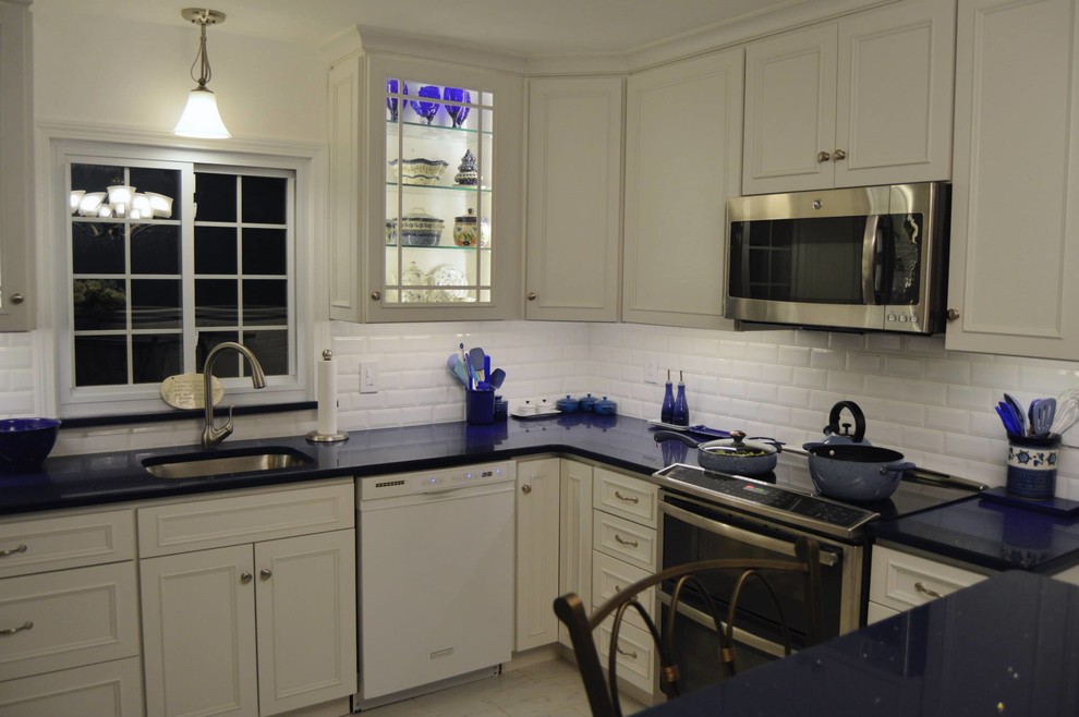Inspiration for a large kitchen remodel in Boston with white cabinets, white backsplash, stainless steel appliances and an island