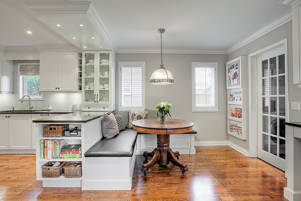 Design ideas for a transitional eat-in kitchen in Toronto with an undermount sink, recessed-panel cabinets, white appliances and medium hardwood floors.