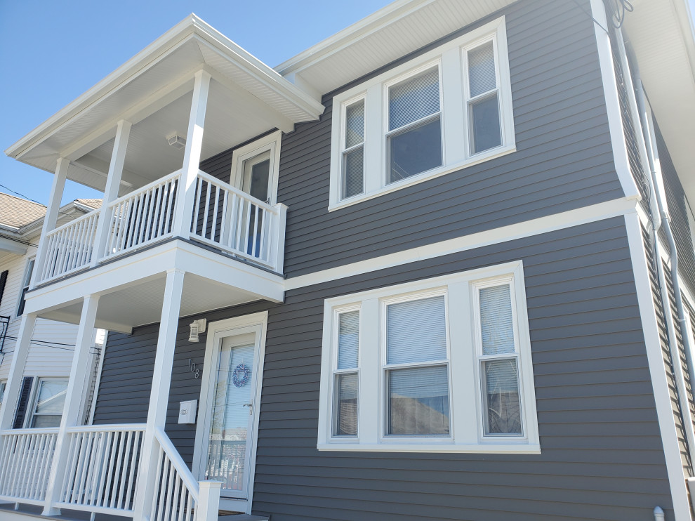 Example of a blue vinyl and clapboard apartment exterior design in Providence