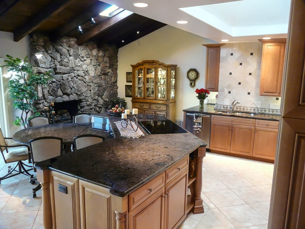 Expansive transitional l-shaped open plan kitchen in San Diego with an undermount sink, raised-panel cabinets, medium wood cabinets, granite benchtops, beige splashback, stone tile splashback, stainless steel appliances, porcelain floors and with island.