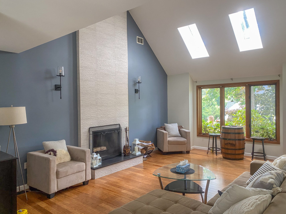 Design ideas for an expansive contemporary living room in Bridgeport with grey walls, a standard fireplace, a tile fireplace surround, brown floor, vaulted and bamboo floors.