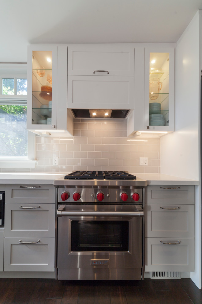 Example of a mid-sized eclectic u-shaped dark wood floor eat-in kitchen design with shaker cabinets, gray cabinets, quartz countertops, gray backsplash, subway tile backsplash, stainless steel appliances and no island