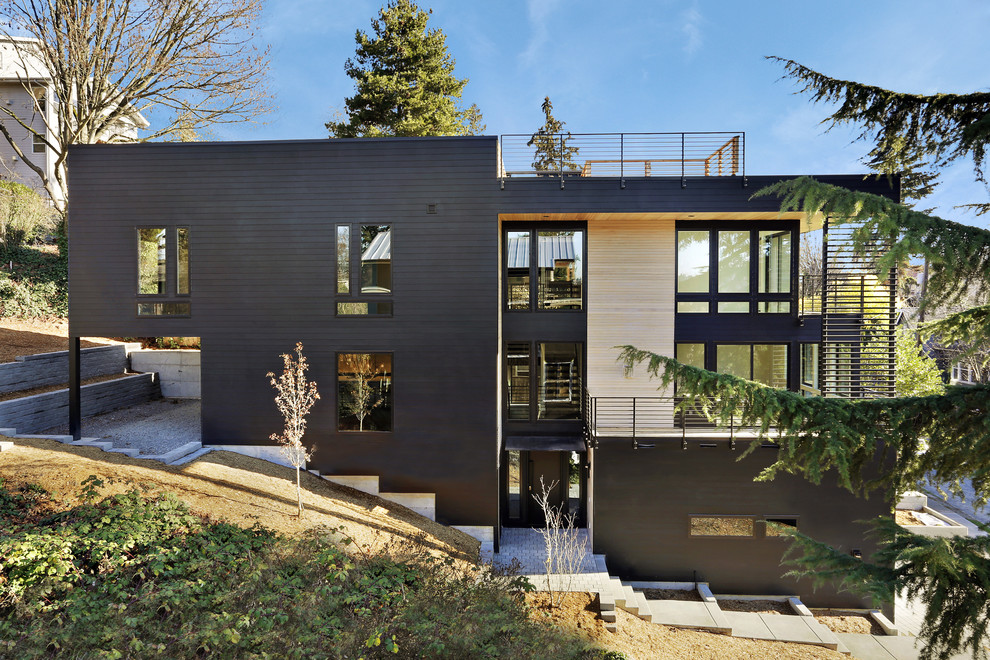 Inspiration for a mid-sized contemporary three-storey black house exterior in Seattle with concrete fiberboard siding and a flat roof.
