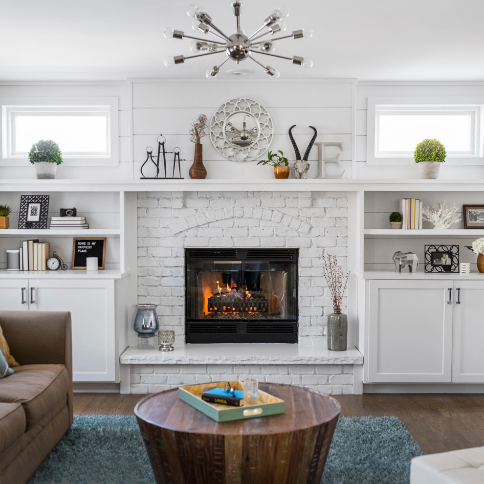 Photo of a mid-sized transitional open concept family room in Chicago with white walls, medium hardwood floors, a standard fireplace, a brick fireplace surround, a wall-mounted tv, planked wall panelling and brown floor.