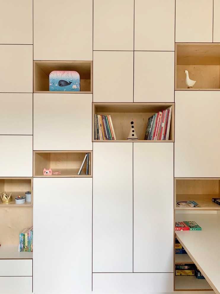 Photo of a mid-sized contemporary kids' playroom for kids 4-10 years old and girls in Berlin with white walls, light hardwood floors and brown floor.