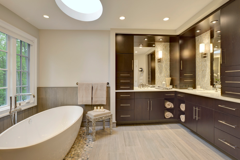 Inspiration for a large contemporary master bathroom in New York with flat-panel cabinets, dark wood cabinets, marble benchtops, gray tile, porcelain tile, a freestanding tub, a one-piece toilet, an undermount sink, grey walls, porcelain floors, a corner shower, beige floor and a hinged shower door.
