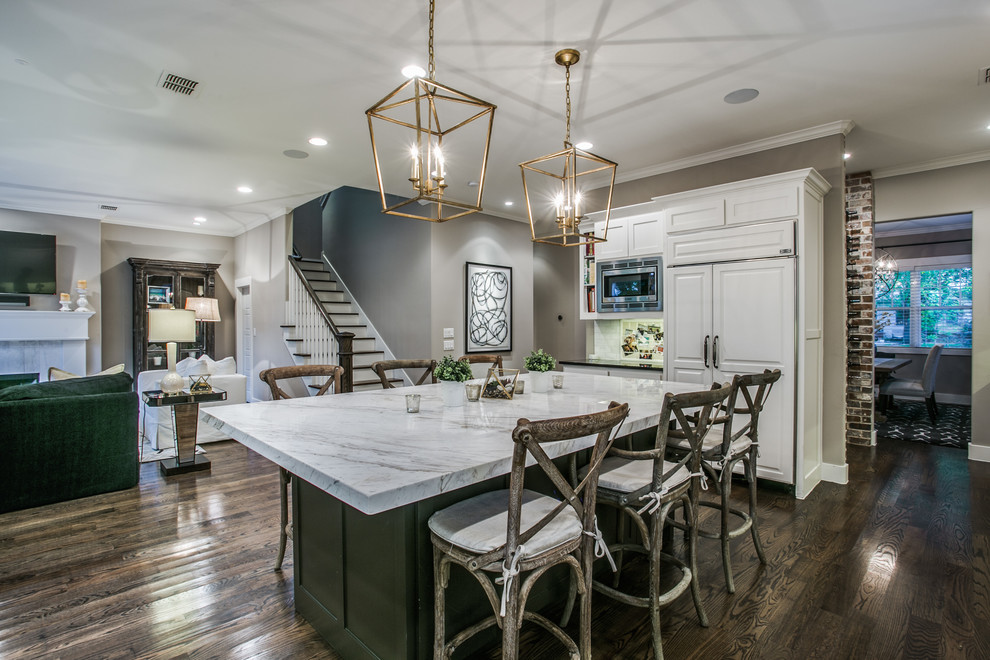 Large contemporary u-shaped open plan kitchen in Dallas with a drop-in sink, shaker cabinets, white cabinets, quartz benchtops, white splashback, limestone splashback, stainless steel appliances, medium hardwood floors, multiple islands, brown floor and black benchtop.