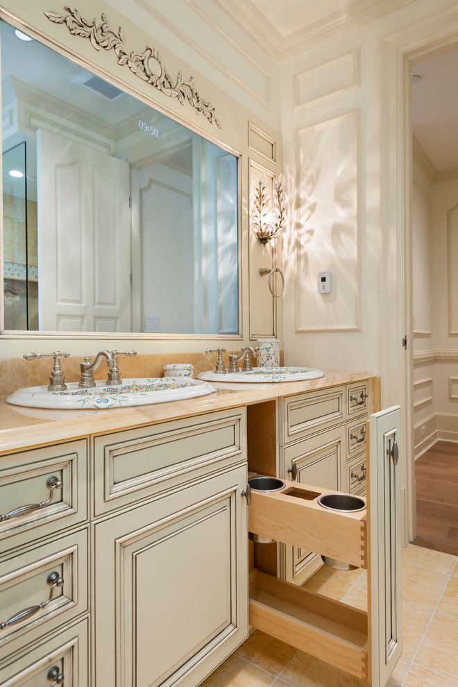 Design ideas for a traditional master bathroom in Vancouver with a drop-in sink, raised-panel cabinets, distressed cabinets, onyx benchtops, a claw-foot tub, a corner shower, a two-piece toilet, yellow tile, stone tile, white walls and marble floors.