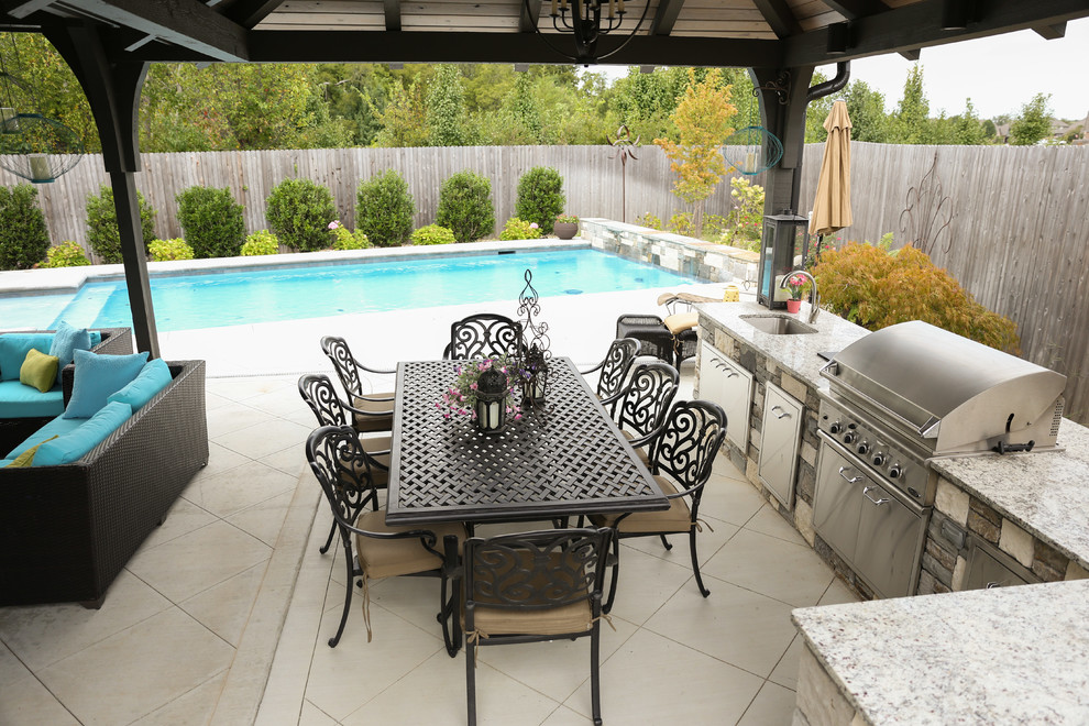 Example of a large transitional backyard tile patio kitchen design with a gazebo