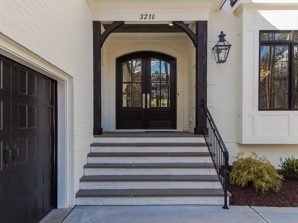 Mid-sized transitional two-story stucco white entryway photo in Raleigh with a clipped gable roof and a tile roof