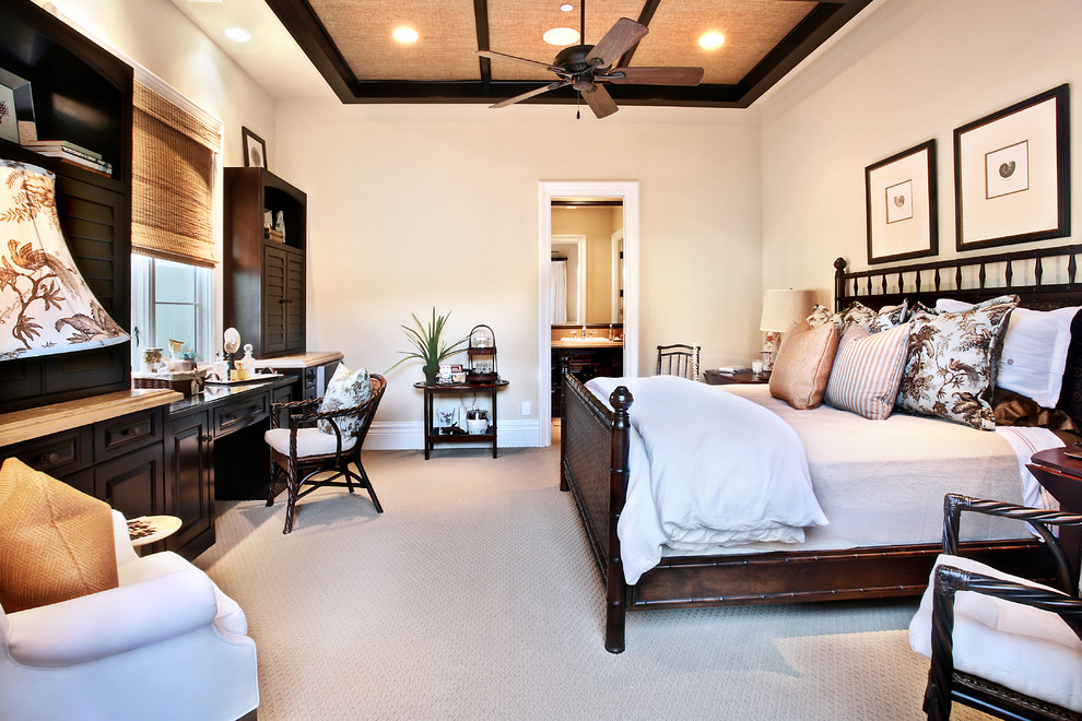 This is an example of a large mediterranean master bedroom in Orange County with beige walls and carpet.