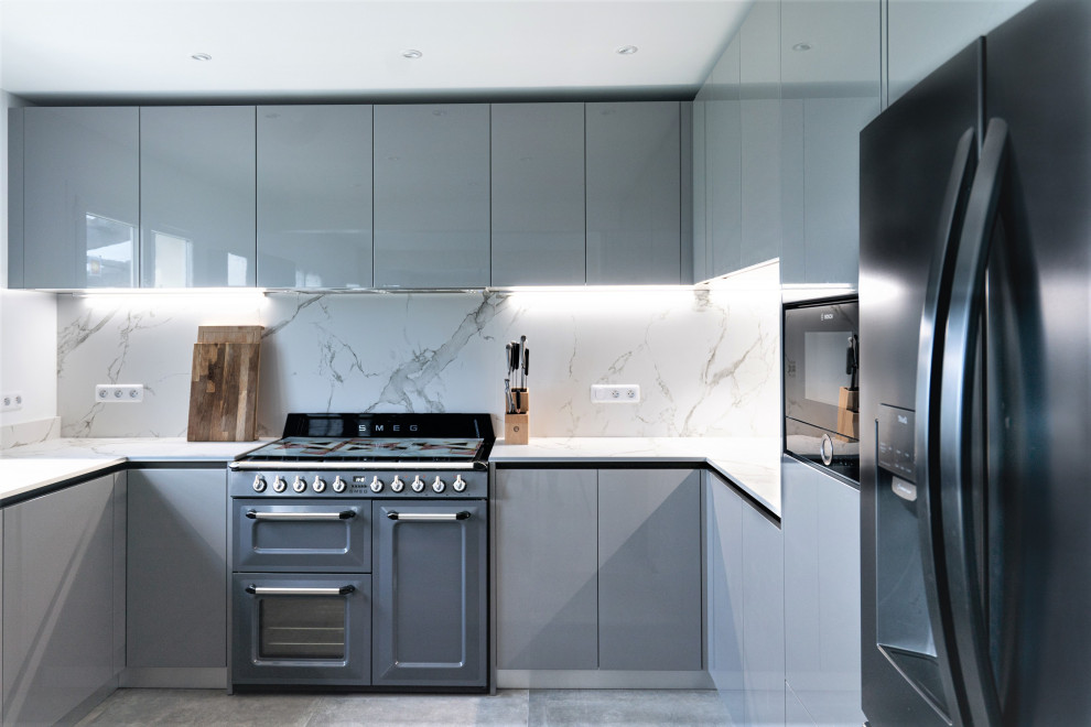 This is an example of a large modern galley open plan kitchen in Other with an integrated sink, recessed-panel cabinets, grey cabinets, marble benchtops, white splashback, marble splashback, panelled appliances, cement tiles, with island, grey floor and white benchtop.