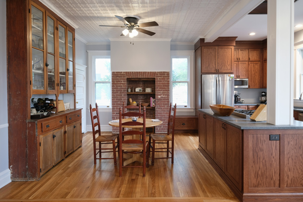 This is an example of a large classic l-shaped kitchen/diner in Baltimore with a submerged sink, shaker cabinets, medium wood cabinets, granite worktops, stainless steel appliances, light hardwood flooring, an island, brown floors, grey worktops and exposed beams.