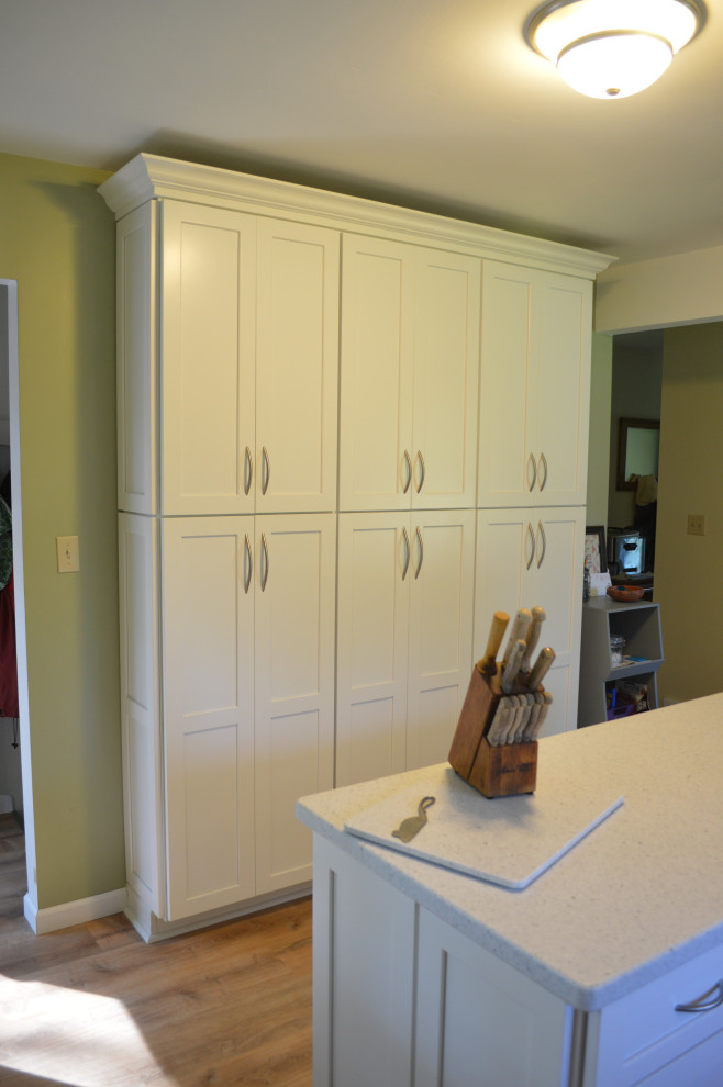 Inspiration for a small transitional single-wall vinyl floor eat-in kitchen remodel with an undermount sink, shaker cabinets, gray cabinets, solid surface countertops, stainless steel appliances, an island and white countertops