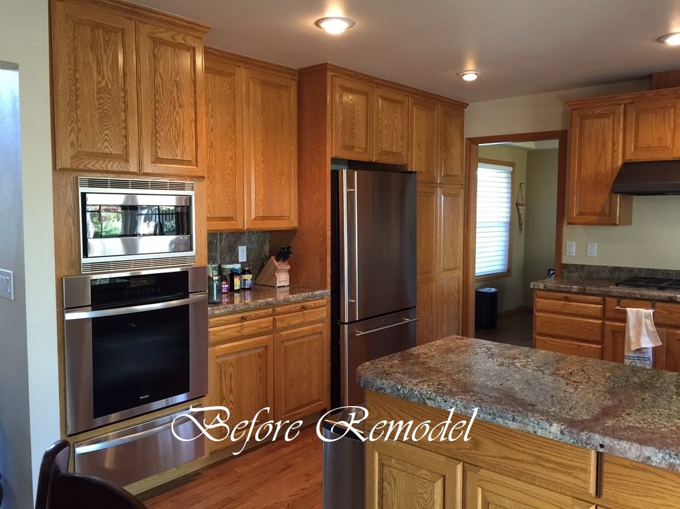 Example of a transitional medium tone wood floor and brown floor kitchen design in Seattle with an undermount sink, raised-panel cabinets, brown cabinets, granite countertops, brown backsplash, stainless steel appliances and brown countertops