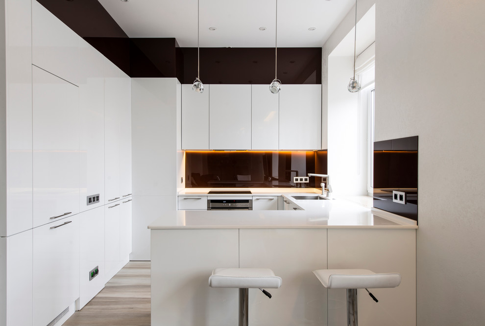 Mid-sized contemporary u-shaped eat-in kitchen in Moscow with flat-panel cabinets, quartz benchtops, brown splashback, glass sheet splashback, with island, an undermount sink, stainless steel appliances and porcelain floors.