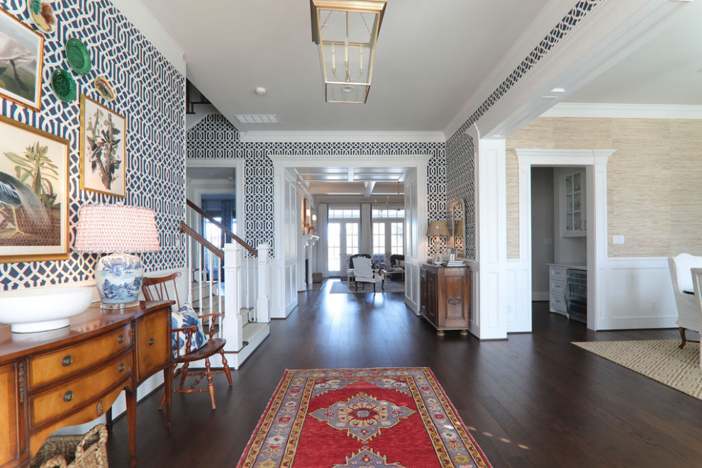 Großes Klassisches Foyer mit weißer Wandfarbe, dunklem Holzboden, Einzeltür, heller Holzhaustür, braunem Boden und Tapetenwänden in Houston